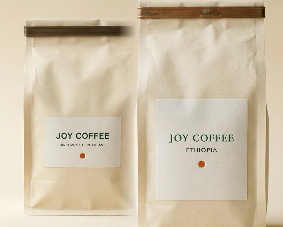 Coffee being poured from a French press next to a bag of coffee